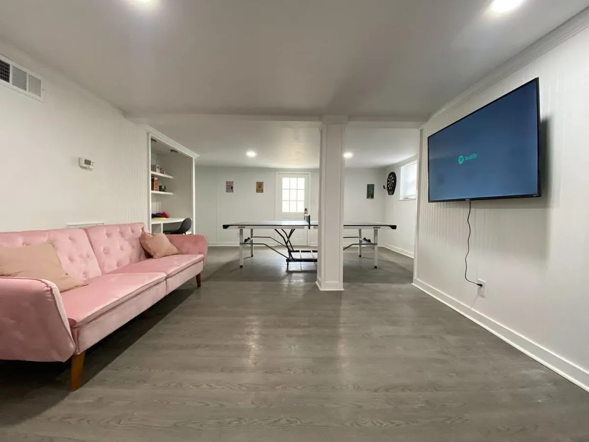 Inside, a lively game room with a pink couch, ping pong table, and large TV creates a fun and social atmosphere, perfect for post-nightlife gatherings or private after-parties.