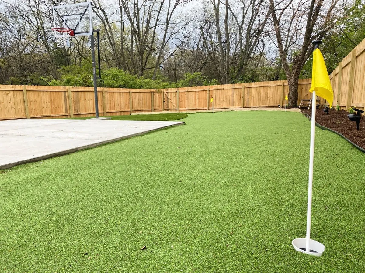 The photo features a private backyard with a basketball hoop, putting green, and a fenced area, perfectly illustrating the range of recreational amenities available for guests. The mood is energetic yet relaxed, with ample space for both games and gatherings.